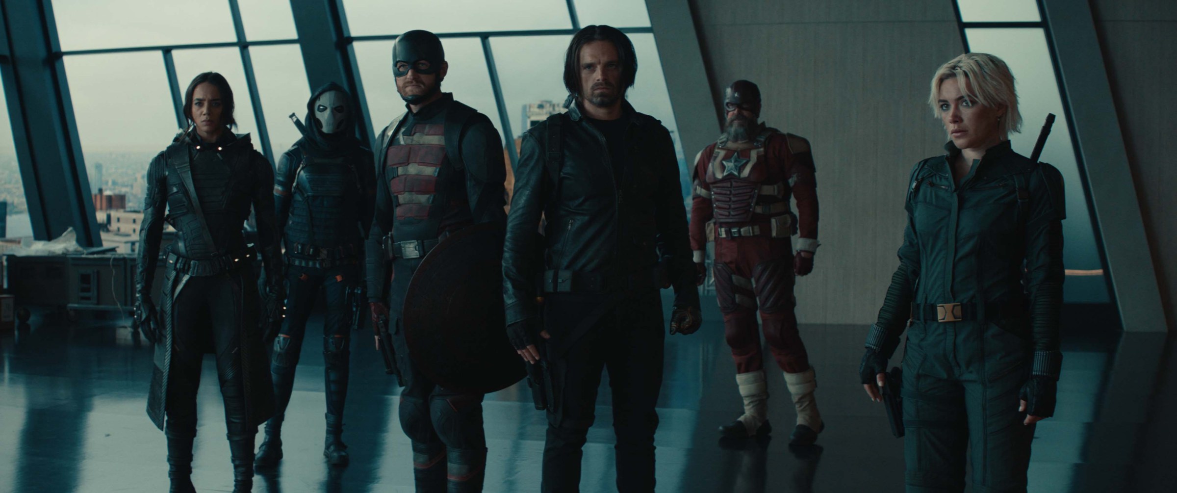 (L-R): Ghost (Hannah John-Kamen), Taskmaster (Olga Kurylenko), John Walker (Wyatt Russell), Bucky Barnes (Sebastian Stan), Alexei Shostakov/Red Guardian (David Harbour), and Yelena Belova standing grimly in a grim penthouse-type room in Thunderbolts*.